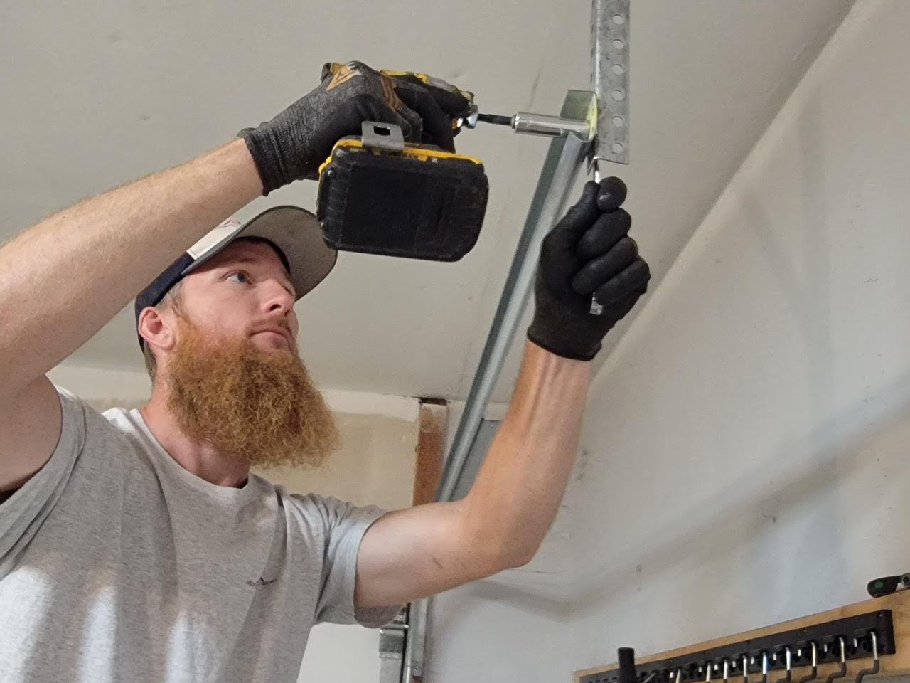 Technician installing garage door track bracket