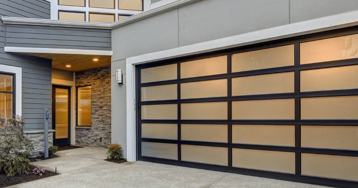 Modern glass-panel garage door at dusk.