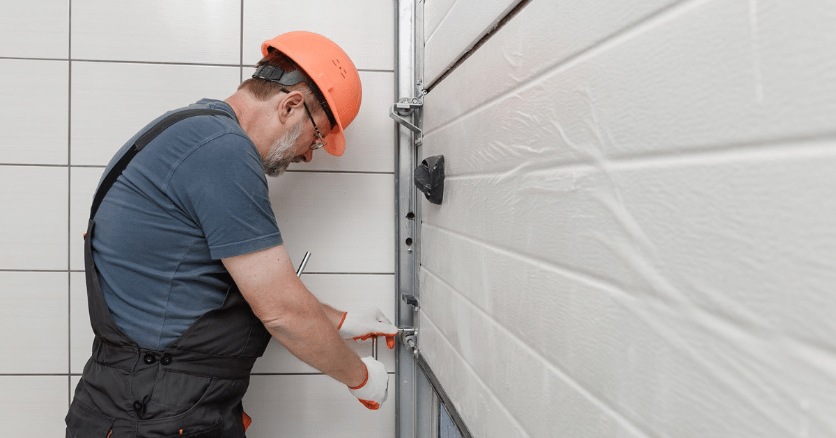 Technician fixing white garage door track.